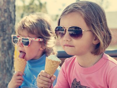 Two little girls (sisters) eating ice cream.